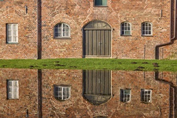 Window and Tor tor of the historic salt storehouse, symmetrical reflection on the water surface of