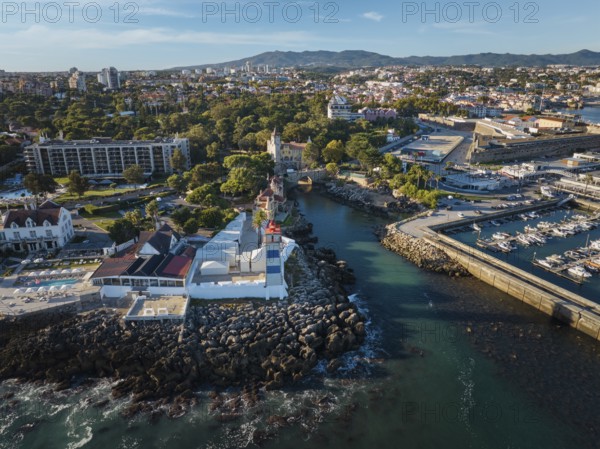 Aerial view of Santa Marta lighthouse and Cascais marina with moored yacht boats with Cascais