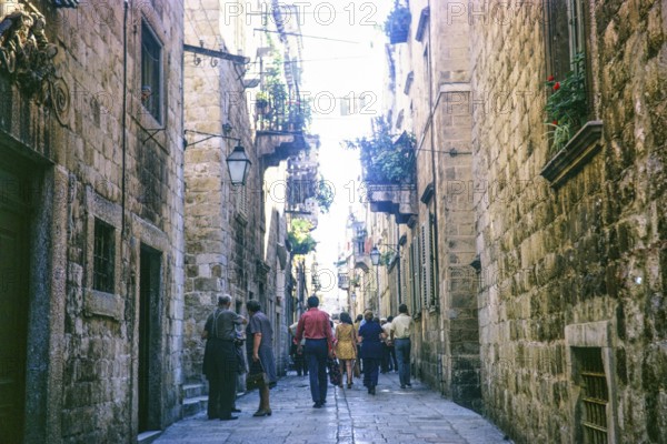 People walking along narrow street in old town of Dubrovnik, Croatia, former Yugoslavia, Europe