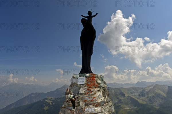 Figure of the Virgin Mary with child against the light on the summit of Mont Noble, Nax,