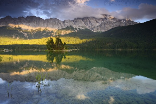 Evening mood at the Eibsee lake, behind the Wetterstein mountains with the Zugspitze, clouds move