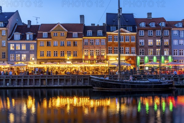 Colourful houses, restaurants and historic ships on the Nyhavn canal and harbour at dusk,