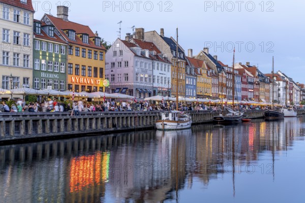 Colourful houses, restaurants and historic ships on the Nyhavn canal and harbour at dusk,