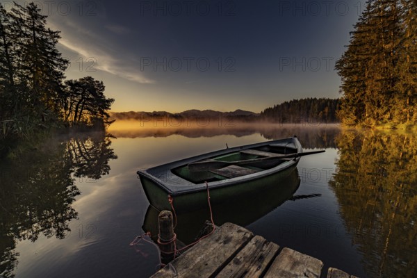 Boats in the autumnal Schmutter Weiher in the Allgäu near the municipalities of Halblech,