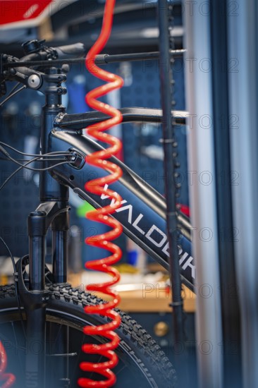 Close-up of a bicycle with a red inner tube in a workshop environment, focus on technology,