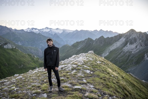 Hiker enjoying the mountain panorama in the morning, Venediger group, behind Dreiherrenkopf,