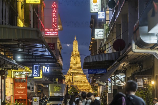 Wat Arun, Temple of Dawn at sunset with dark clouds. Boats on the Chao Phraya river. Tourist