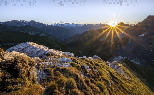 Mountain landscape at sunrise with sun star, view of mountain peaks of the Venediger group and into