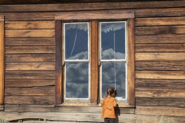 Bodie, California - A child looks in the window of the old schoolhouse at Bodie State Historic Park