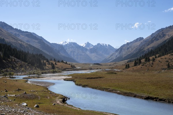 Mountain river in a picturesque mountain valley, mountain landscape with white mountain peaks, Tian