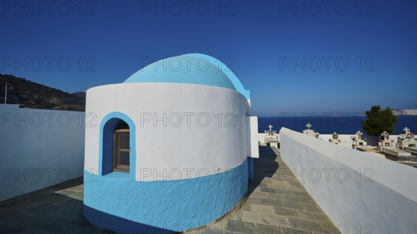 White and blue chapel next to a cemetery with sea view, Pali village, Pali, Volcanic Island,