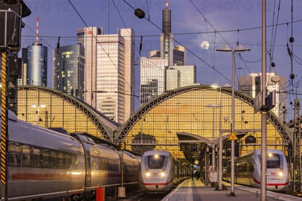 Frankfurt main station with ICE train in the evening, full moon and sunset. View of platform and