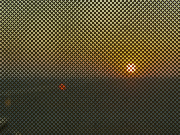 Berlin BER Airport, view through perforated window panes, taxiway at sunrise in November, Berlin,