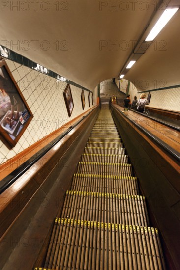 Passers-by on a wooden escalator in the Sint-Annatunnel, heritage-protected St Anne's Tunnel under