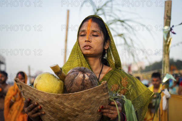 Hindu devotees perform rituals as they offer prayers to the Sun god in the bank of Brahmaputra