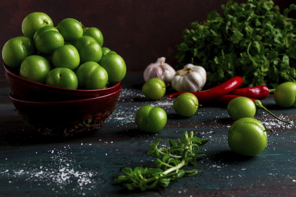 Tkemali, green cherry plum, with ingredients for sauce, cilantro, mint, hot pepper, garlic, on a