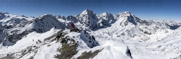 Ski tourers on foot, mountain panorama with snow-covered mountain landscape in winter, view of