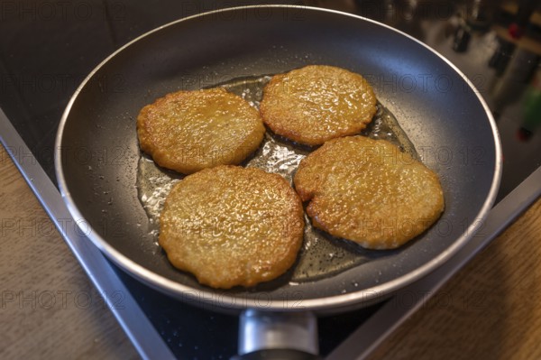 Freshly baked potato pancakes in the pan on the cooker, Bavaria, Germany, Europe