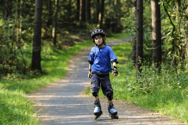 Boy, 8 years, inline skates, bike path in the woods, at the B191 Celle-Lachendorf, Lower Saxony,