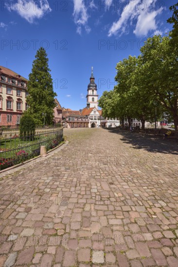 Church tower, Erbach town church, trees, cobblestone square, blue sky with cumulus clouds, market