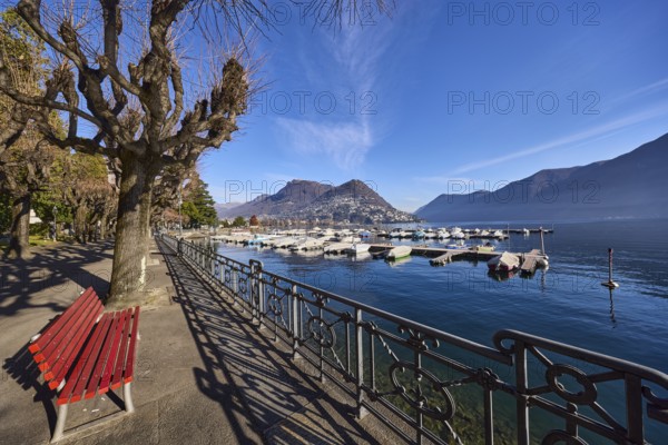 Lake, lakeside promenade, trees, railing, bench, shadow, hilly landscape, marina, motorboats, haze,