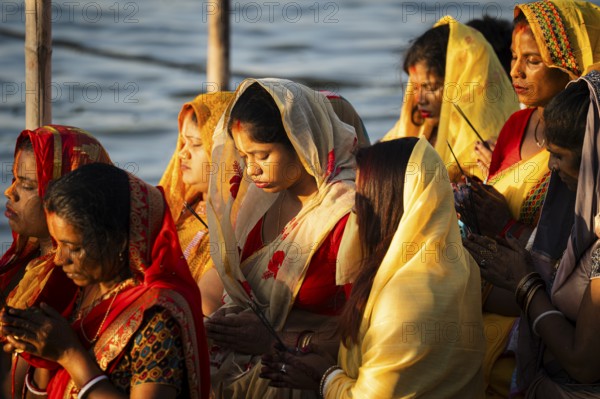 Hindu devotees perform rituals as they offer prayers to the Sun god in the bank of Brahmaputra