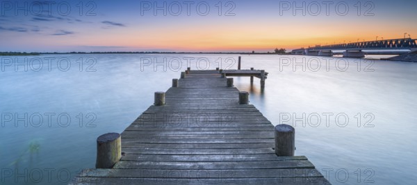 Jetty on the Peene River at sunset, behind the bascule bridge to the island of Usedom,