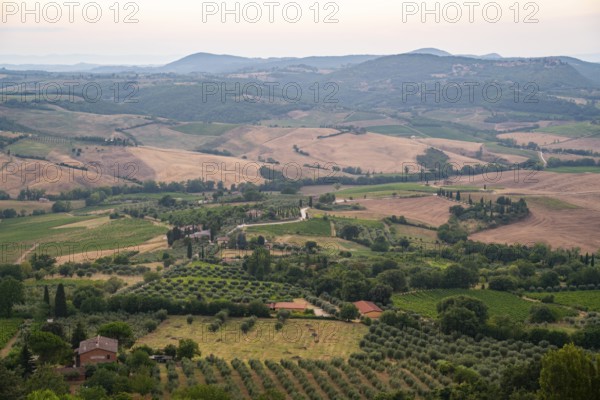View from Montepulciano into a typical Tuscan landscape in Val d'Orcia with hills, trees, fields,