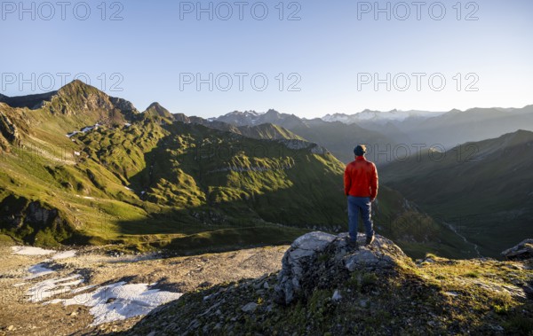 Mountaineer in front of mountain landscape at sunrise, view of mountain peaks of the Venediger