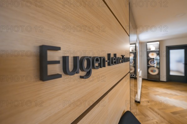 Modern hallway with wooden wall and the lettering 'Lehre-Zimmer', behind it a seating area, Nagold