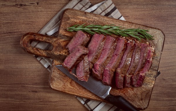 Fried steak, beef steak, rib eye steak, sliced steak, on a chopping board, top view, no people
