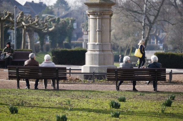 Krefeld, North Rhine-Westphalia, Germany - Senior citizens sitting on a park bench in the district