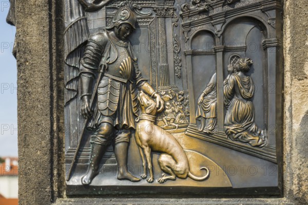 Bronze relief of a nobleman with a dog, laying hands on the relief of the dog is said to bring good