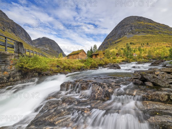 Autumn in Reinheimen National Park, cabins with green roofs, mountains with river in Valldalen