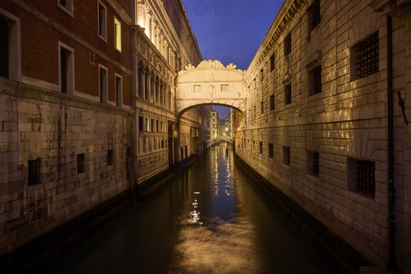 View from 'Ponte della paglia' on the bridge 'Bridge of Sighs' over a waterway at the blue hour in
