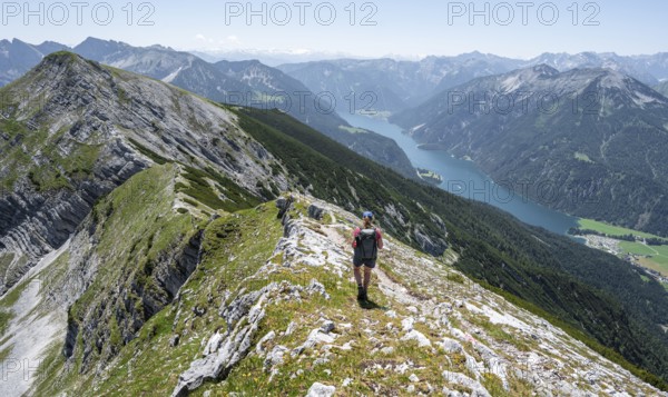Mountaineer on the summit ridge of the Unnütz, behind Achensee and summit of the Seekarspitze
