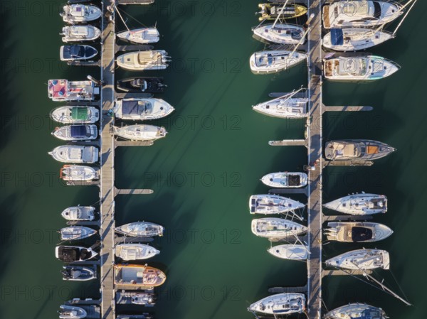 Marina with yachts aerial drone top down view. Boats and yachts moored by the pier. Cascais,