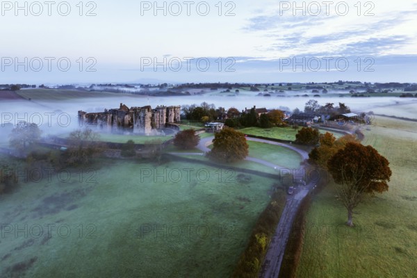 Raglan Castle in the fog at dawn from a drone, Monmouthshire, Wales, England, United Kingdom,
