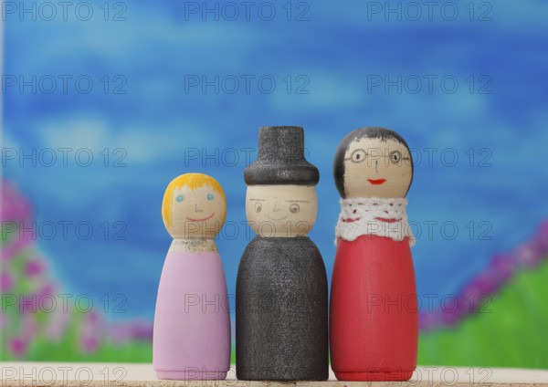 Three funny painted wooden cones in front of a painted background, North Rhine-Westphalia, Germany,
