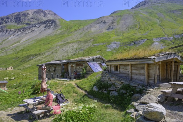 Woman enjoying a coffee break at the Chalet refuge de Chamoissiére, Villar-d'Arêne, Département