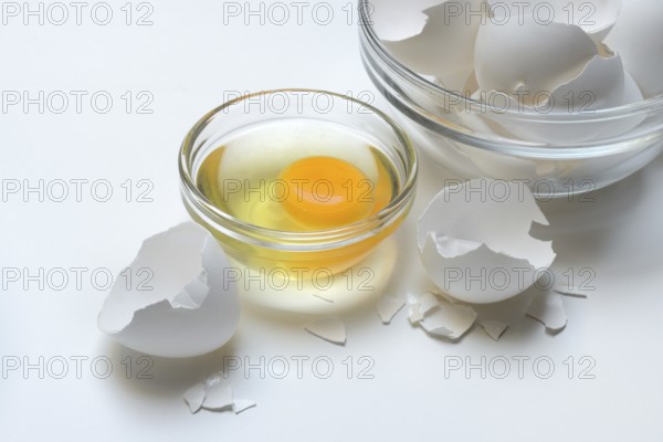 Egg whites and egg yolks in glass bowl and egg shells, whisk