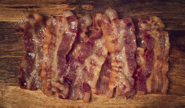 Fried bacon on a cutting board, top view, close-up, homemade, breakfast, no people