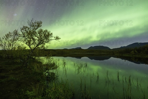 Northern lights reflected in lake, Lapporten, Abisko National Park, Lapland, Sweden, Europe