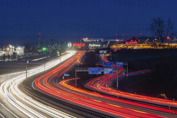 A8 motorway at Stuttgart Airport in the evening. Heavy traffic, lanes of light. Modern architecture