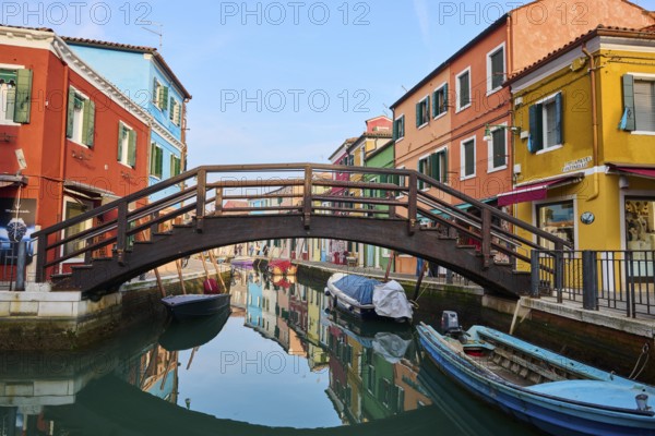 Colorful houses and a bridge 'Love viewing bridge' going over the waterway with boats lying in the