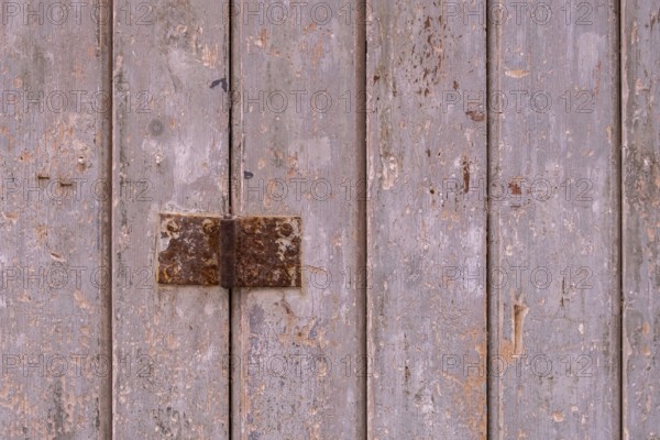 Old wooden door with peeling paint and metal fittings, texture, background, Apulia, Italy, Europe