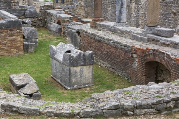 High angle view of old semi circle grey stone structure, terracotta brick wall and columns at