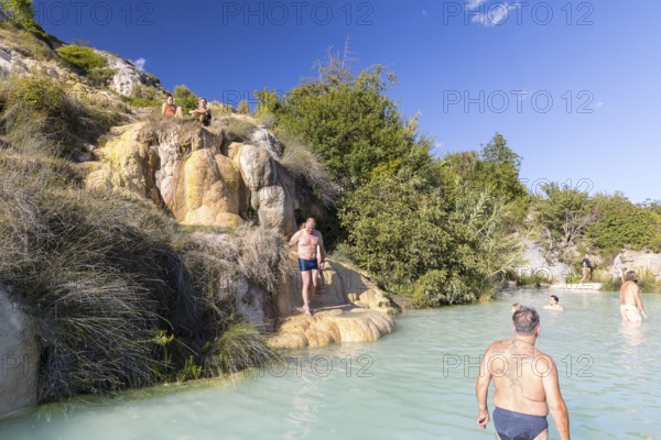 Bathers in one of the thermal pools between the cascades in the limestone on the steep slope of the