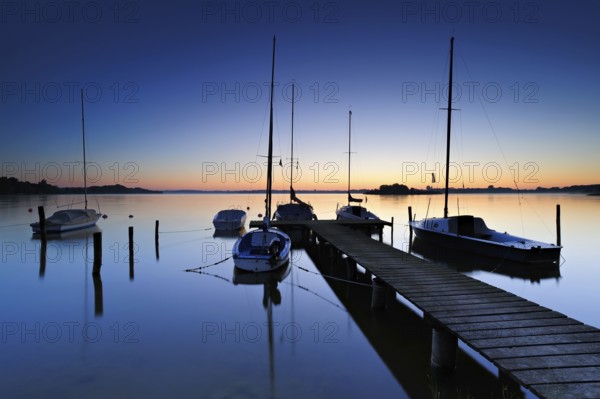 Dawn on the Schaalsee, wooden jetty with sailing boats, Schaalsee Biosphere Reserve,