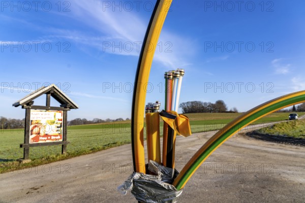 Fibre optic connection, empty conduits protrude from the ground along a dirt track, into which the